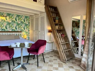 a bedroom with a bed and a table and chairs at Holiday Home Das Atelier im Mas Naste by Interhome in Eygalières