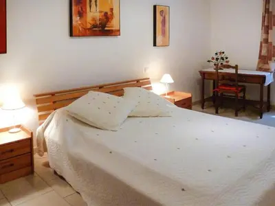 a bedroom with a white bed and a desk at Apartment Morard - Bonnieux Appt Bleu Provence by Interhome in Bonnieux