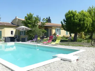 a swimming pool with chairs and a house at Villa en Provence in Le Thor