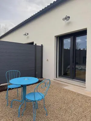 a blue table and two chairs on a patio at Esprit Lubéron, Le Romarin, logement entier in Le Thor