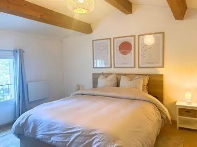 a bedroom with a large bed with two pictures on the wall at Maison cosy avec parking privé proche centre Aix en Provence in Aix-en-Provence