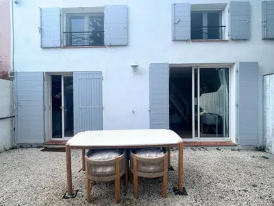 a table and two chairs in front of a building at Maison cosy avec parking privé proche centre Aix en Provence in Aix-en-Provence