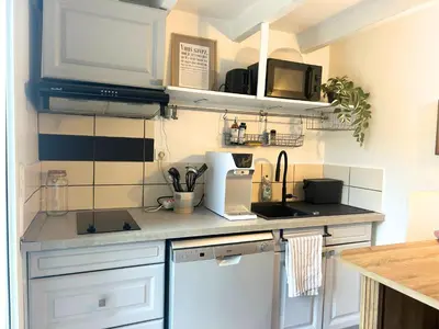 a kitchen with white cabinets and a counter top at Maison cosy avec parking privé proche centre Aix en Provence in Aix-en-Provence