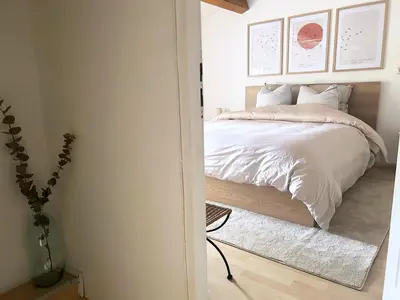 a bedroom with a bed with white sheets at Maison cosy avec parking privé proche centre Aix en Provence in Aix-en-Provence
