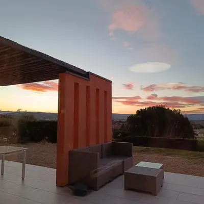 a couch sitting on a patio with a sunset at ChloLéa in Caromb