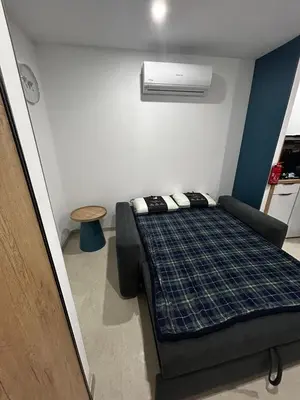 a small bedroom with a bed and a air conditioner at Studio 2 personnes maximum in Saint-Andiol
