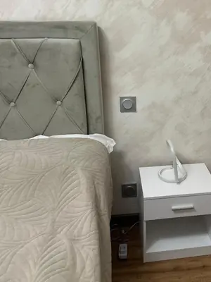 a bedroom with a bed and a white night stand at Le Pavillon Etoile in Venelles