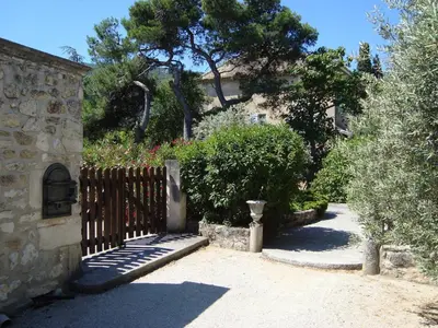 a garden with a wooden fence and trees and bushes at Danie, maison des oliviers et vue Luberon in Maubec
