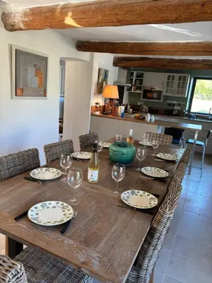 a wooden table with glasses and a bottle of wine at Le Mas des Grillons, mas rénové entièrement climatisé avec piscine et vue Ventoux in Crillon-le-Brave