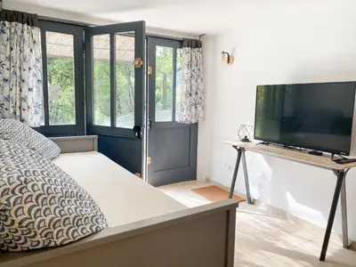 a bedroom with a bed and a flat screen tv at LAVANDE in Apt
