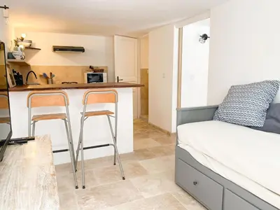 a kitchen with a counter and two stools in a room at LAVANDE in Apt