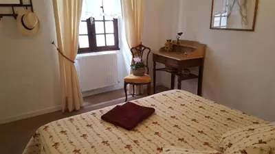 a bedroom with a bed and a desk and a sink at Les Roues de L'Isle - CHARMING APARTMENT in LʼIsle-sur-la-Sorgue