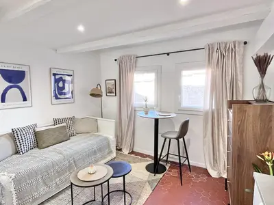 a living room with a couch and a table at Aix-en-Provence, Studio rénové au coeur de ville Calme absolu in Aix-en-Provence