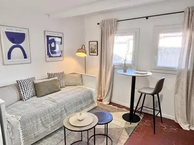 a living room with a couch and a table at Aix-en-Provence, Studio rénové au coeur de ville Calme absolu in Aix-en-Provence
