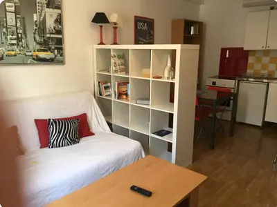 a living room with a couch and a book shelf at appartement de charme au coeur d'aix en provence in Aix-en-Provence