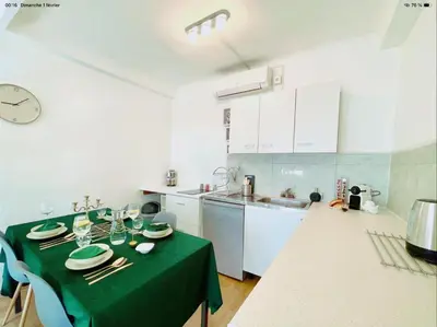 a kitchen with a table with a green table cloth at appartement de charme au coeur d'aix en provence in Aix-en-Provence