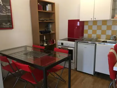 a kitchen with a glass table and red chairs at appartement de charme au coeur d'aix en provence in Aix-en-Provence