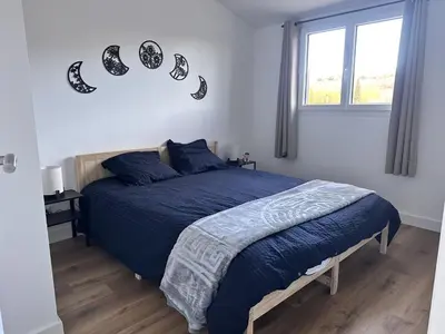 a bedroom with a bed with blue sheets and footprints on the wall at L'abeille sous les étoiles in Saint-Michel-lʼObservatoire