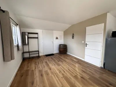 an empty room with white walls and wood floors at L'abeille sous les étoiles in Saint-Michel-lʼObservatoire