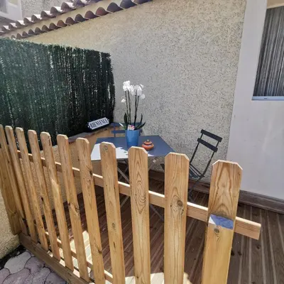a wooden fence with a table with flowers on it at Charmant studio aux portes des Alpilles in Eyguières