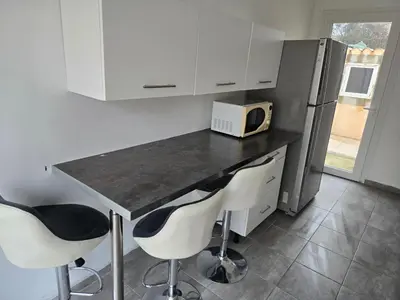 a kitchen with a counter with two chairs and a microwave at Le cocon de mag in Miramas