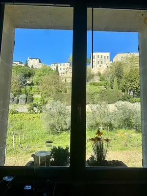 a window with a view of a field and buildings at Cocon en Provence à Ménerbes in Ménerbes