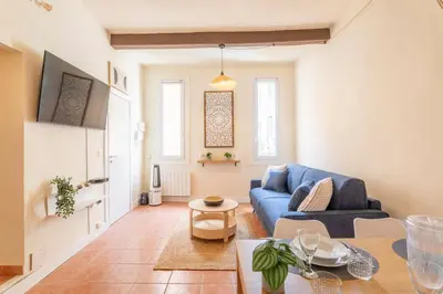 a living room with a blue couch and a table at Le Petit Saint Esprit, centre, calme, lumineux in Aix-en-Provence