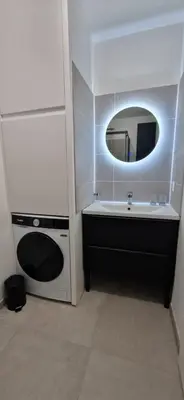 a bathroom with a sink and a tub and a mirror at superbe escapade au cœur de la ville clim parking et piscine in Aix-en-Provence