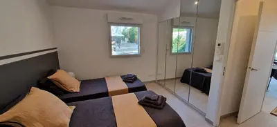 a bedroom with a bed and a mirror at superbe escapade au cœur de la ville clim parking et piscine in Aix-en-Provence
