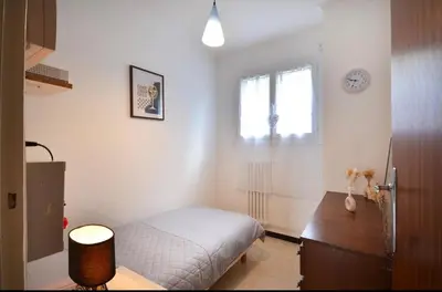 a bedroom with a bed and a desk and a window at Les Volets Bleus Provençal house with pool in LʼIsle-sur-la-Sorgue