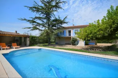 a swimming pool in front of a house at Les Volets Bleus Provençal house with pool in LʼIsle-sur-la-Sorgue