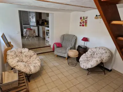 a living room with two chairs and a table at Gîte Moulin de l'Anet in Goult
