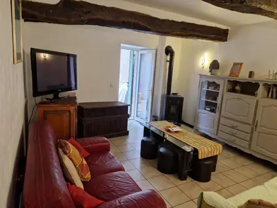 a living room with a couch and a tv at Gîte Moulin de l'Anet in Goult