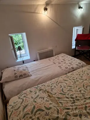 a bedroom with two beds and a window at Gîte Moulin de l'Anet in Goult