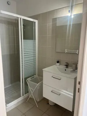 a bathroom with a shower and a sink and a mirror at Appartement 4 personnes 5 minutes a pieds du centre ville parking gratuit jardin 85m2 in LʼIsle-sur-la-Sorgue