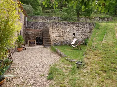 a stone building with a bench in a yard at le Mas caché in Ménerbes
