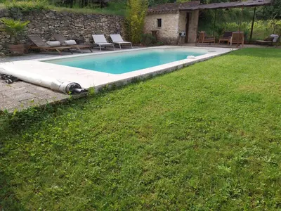 a swimming pool in a yard next to a grass field at le Mas caché in Ménerbes