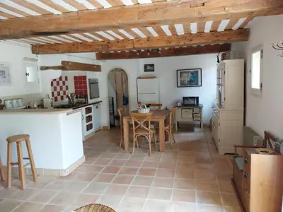 a kitchen and dining room with a table and chairs at le Mas caché in Ménerbes