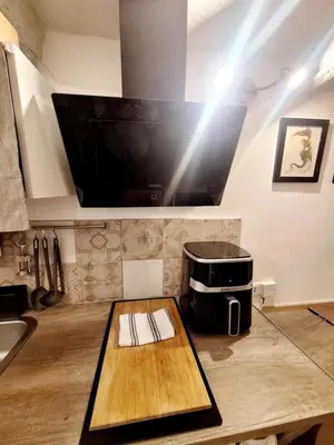 a kitchen with a table with a large tv on the wall at Le Cocon d'Emy in Aix-en-Provence