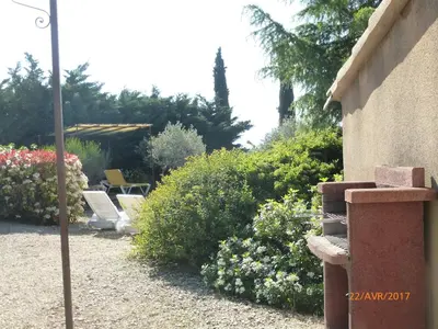 a garden with a couple of chairs and flowers at Très charmant Mazet au coeur du Luberon in Roussillon