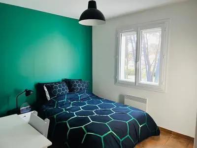 a bedroom with a bed and a green wall at Une maison provençale dans la pinède - A Provençal house in a pine forest in Lambesc