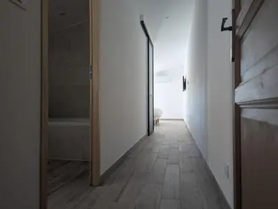 a hallway with a door leading to a bathroom at La Ferme Au bord de l etang de la Bonde in Sannes