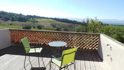 a table and chairs on a deck with a view at Maison Les Bruns, sur la route du Mont Ventoux in Bédoin