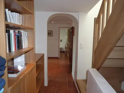 a hallway with bookshelves and a staircase in a house at Maison Les Bruns, sur la route du Mont Ventoux in Bédoin