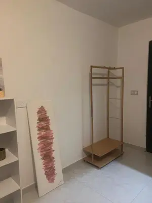 a room with a white wall with a wooden shelf at Appartement cosy & calme avec parking privé & terrasse in Mazan
