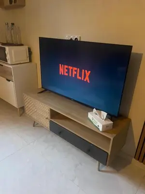 a flat screen tv sitting on top of a wooden entertainment center at Appartement cosy & calme avec parking privé & terrasse in Mazan