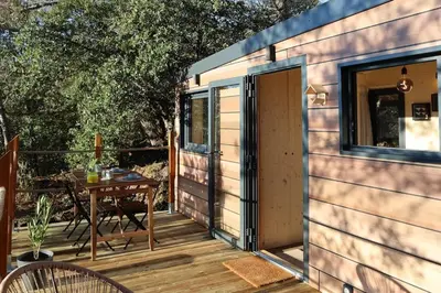a tiny house with a table on a deck at Tiny House Sainte Victoire - Brasserie Aix Pression in Rognes