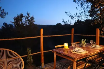 a wooden table with wine glasses on a patio at Tiny House Sainte Victoire - Brasserie Aix Pression in Rognes