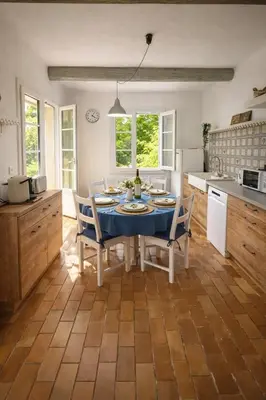 a kitchen with a table and chairs in a kitchen at Mas Caumontois Provençal charm & private pool in Caumont-sur-Durance