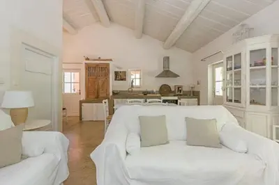 a living room with a white couch and a kitchen at Provençal House With Pool Near Roussillon in Roussillon